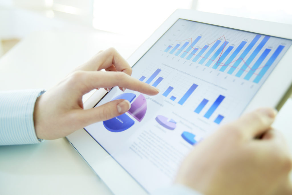 Close-up image of an office worker using a touchpad to analyze statistical data